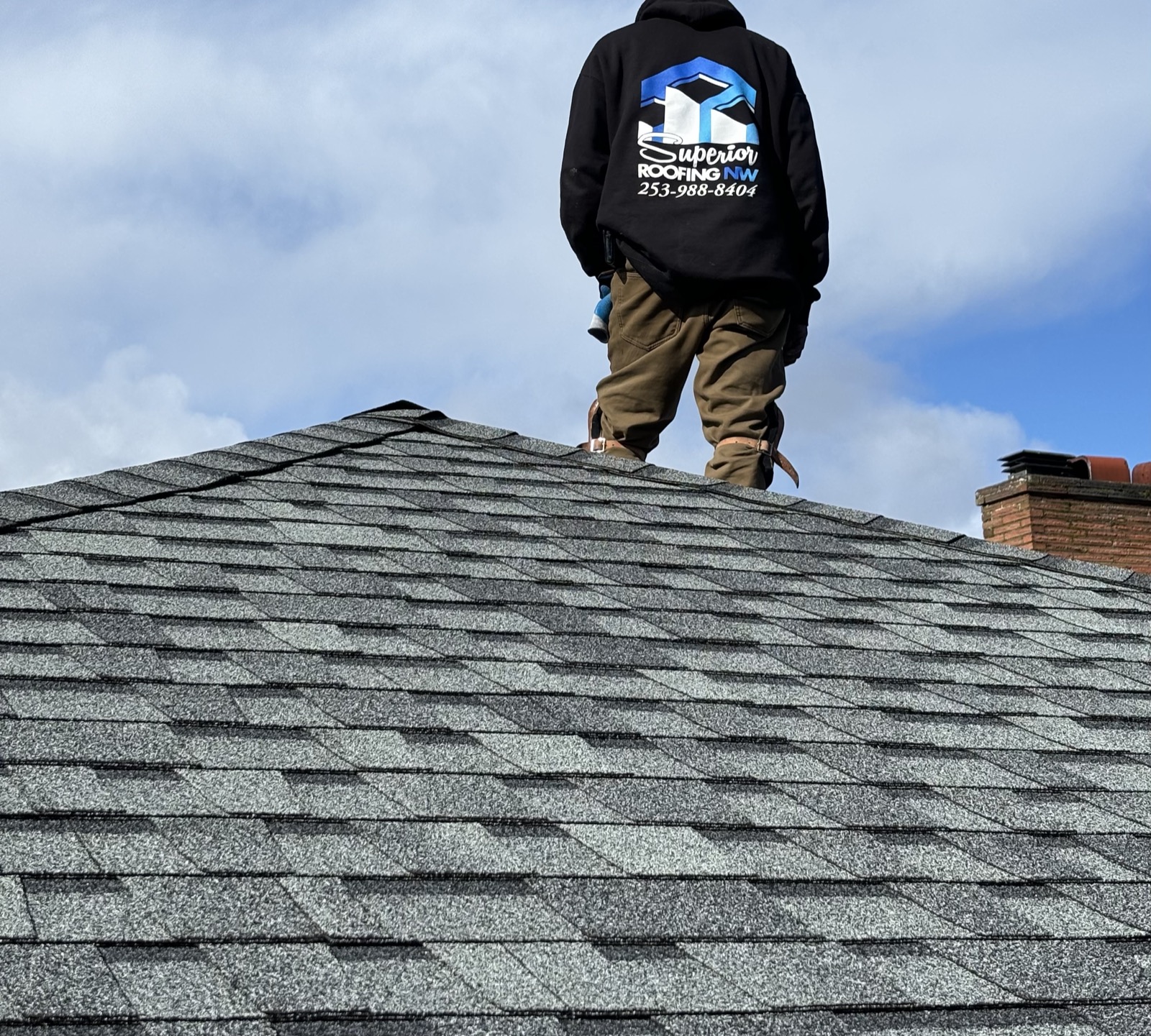 Superior Roofing Northwest roofer standing on a finished shingle roof